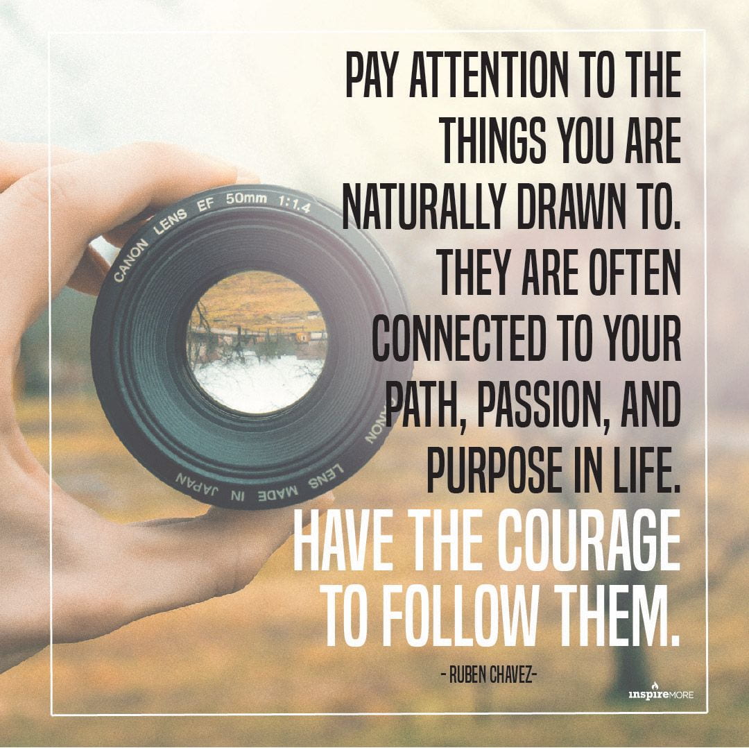 A hand holding a camera lens with the text "Pay attention to the things you are naturally drawn to. They are often connected to your path, passion, and purpose in life. Have the courage to follow them." - Ruben Chavez