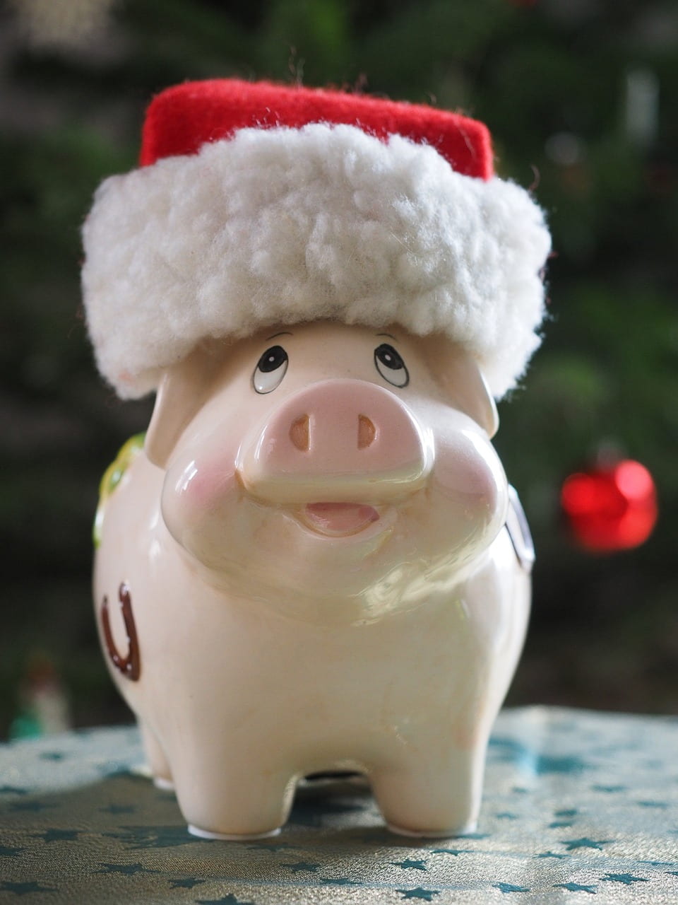 An image of a piggy bank wearing a Santa hat.